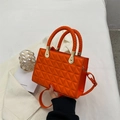 Borsa trapuntata arancione con manico intrecciato e dettagli dorati su sfondo bianco - Arancione