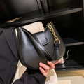 Minimalist black crescent shoulder bag with a matte finish and decorative gold metal chain - Black