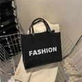 Bolso tote de cuero sintético negro con estampado 'FASHION' blanco y doble asa superior - Negro