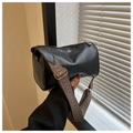 Close-up of black cylinder bag featuring a retro patterned wide shoulder strap detail - Black