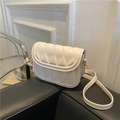 Borsa a tracolla beige vintage con pieghe e dettagli dorati su divano nero - Bianco