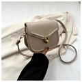 Detailed view of the vintage gold buckle and matte leather texture on the beige saddle bag - Khaki