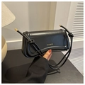Detail of minimalist black rectangle shoulder bag with knotted cord strap and gold logo - Black