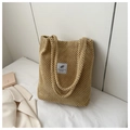 Close-up of beige knitted corduroy tote bag with vintage texture and cloth label - Khaki