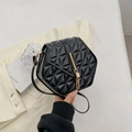 Minimalist black hexagonal crossbody bag with triangular texture and golden tassel detail - Black