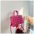 Close-up of rose pink quilted bubble texture and golden metal hooks on handbag - Rose Red