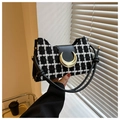 Close-up of black and white checkered tweed handbag with gold crescent metal clasp - Black