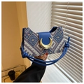 Close-up of geometric jacquard fabric and moon-shaped gold metal buckle on a blue bag - Blue