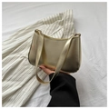 Detail of metallic gold shoulder bag with Fashion & Bags text on white textured bedding - Gold