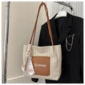 Détail d'un sac cabas en paille avec poche en cuir Summer et foulard en soie décoratif - Marron