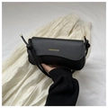Detalle de bolso negro con letras doradas y diseño de correa con nudo elegante - Negro