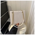 Detail of white chevron quilted bag showing gold chain strap and elegant leather finish - White