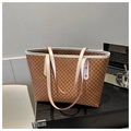 Detail van bruine draagtas met geometrische print en witte handvatten op bureau - Bruin