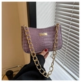 Détail d'un sac à main violet motif crocodile avec une grosse chaîne dorée et plaque en métal - Violet