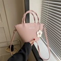 Pink minimalist crossbody bucket bag with woven handles and flower charm pendant - Pink