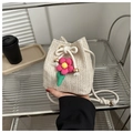 Beige Stroh-Beuteltasche mit Blumenakzent und geflochtenem Kordelzug-Schultergurt für Damen - Gebrochenes Weiß