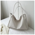 Detail of a minimalist white leather tote bag featuring a golden magnetic closure and thin straps - White Without Pendant