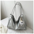 Detail of silver metallic tote bag with fluffy white monster pendant on white fabric - Silver with Charm