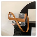 Vista detallada de un bolso bandolera de PVC transparente con ribetes de cuero marrón - Marrón