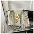 Close-up of beige woven straw tote bag with green straps and yellow floral ornament - Green
