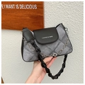 Close-up of grey denim shoulder bag featuring black leather flap and silver chain link - Black