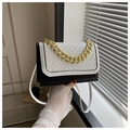 Bolso bandolera bicolor blanco y negro con cadena dorada y detalle de solapa trenzada - Negro