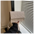 Detalle de bolso cuadrado beige con acolchado geométrico de triángulos y correa - Caqui