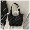 Detail van zwarte gewatteerde shopper met goudkleurig klaverlogo en dubbele hengsels - Zwart