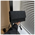 Detalle de un bolso bandolera de fieltro acolchado negro con costuras triangulares - Negro