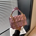 Metallic pink quilted handbag with gold chain strap and pleated handle on windowsill - Pink