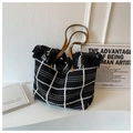 Detailansicht der Strick-Tote-Bag mit schwarz-weißem Karomuster und Fransenquasten - Schwarz