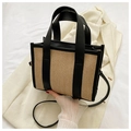 Straw woven rectangular tote bag with black trim and handles on textured background - Black