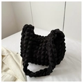 Detalle de la textura de burbujas popcorn negras en el bolso de mano plisado de moda - Negro