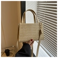 Detail of handwoven beige straw square bag with faux leather handle and gold hardware - Khaki