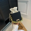 Black textured bucket bag with white drawstring liner and gold chain handle detail - Black