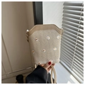 Detailed close-up of straw bucket bag featuring delicate white daisy embroidery patterns - Khaki