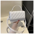 Detail showing white quilted leather texture and adjustable strap on handheld crossbody bag - White