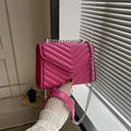 Fuchsia chevron quilted crossbody bag with silver chain strap shown by a model - Rose Red