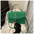 Detail of bright green crocodile embossed handbag with gold buckle and top handle - Green
