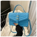 Détail du sac bleu brillant à texture crocodile avec boucle dorée et bandoulière réglable - Bleu