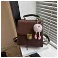 Détail du sac à dos en cuir marron foncé avec fermoir doré et breloque peluche rose - Avec Pendentif / café