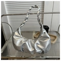 Close-up of silver pleated PU handbag with a unique braided shoulder strap and zipper - White