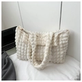Detalle de la textura de burbuja beige y cremallera en un bolso de hombro elegante y moderno - Blanco