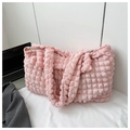 Detalle de la tela con textura de burbujas rosa y correa del bolso en un entorno de estilo - Rosa