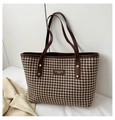 Close-up of vintage houndstooth tote bag with brown leather handles and gold rivet details - Brown