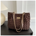 Detail of brown pleated fabric tote bag with textured surface and leather fashion label - Coffee