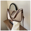 Detail view of beige leather tote bag with contrasting brown trim and gold metal buckles - Khaki