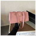 Gros plan du sac à main rose texture crocodile avec boucle en métal doré élégante - Rose