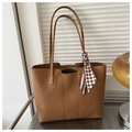 Detail of a large brown tote bag featuring slender shoulder straps and a checkerboard scarf - Brown