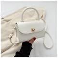 Detail of a white crossbody bag with a round gold buckle and smooth leather finish - White